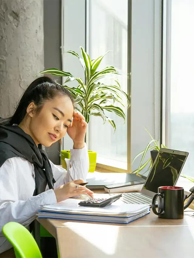 a woman looking at a calculator