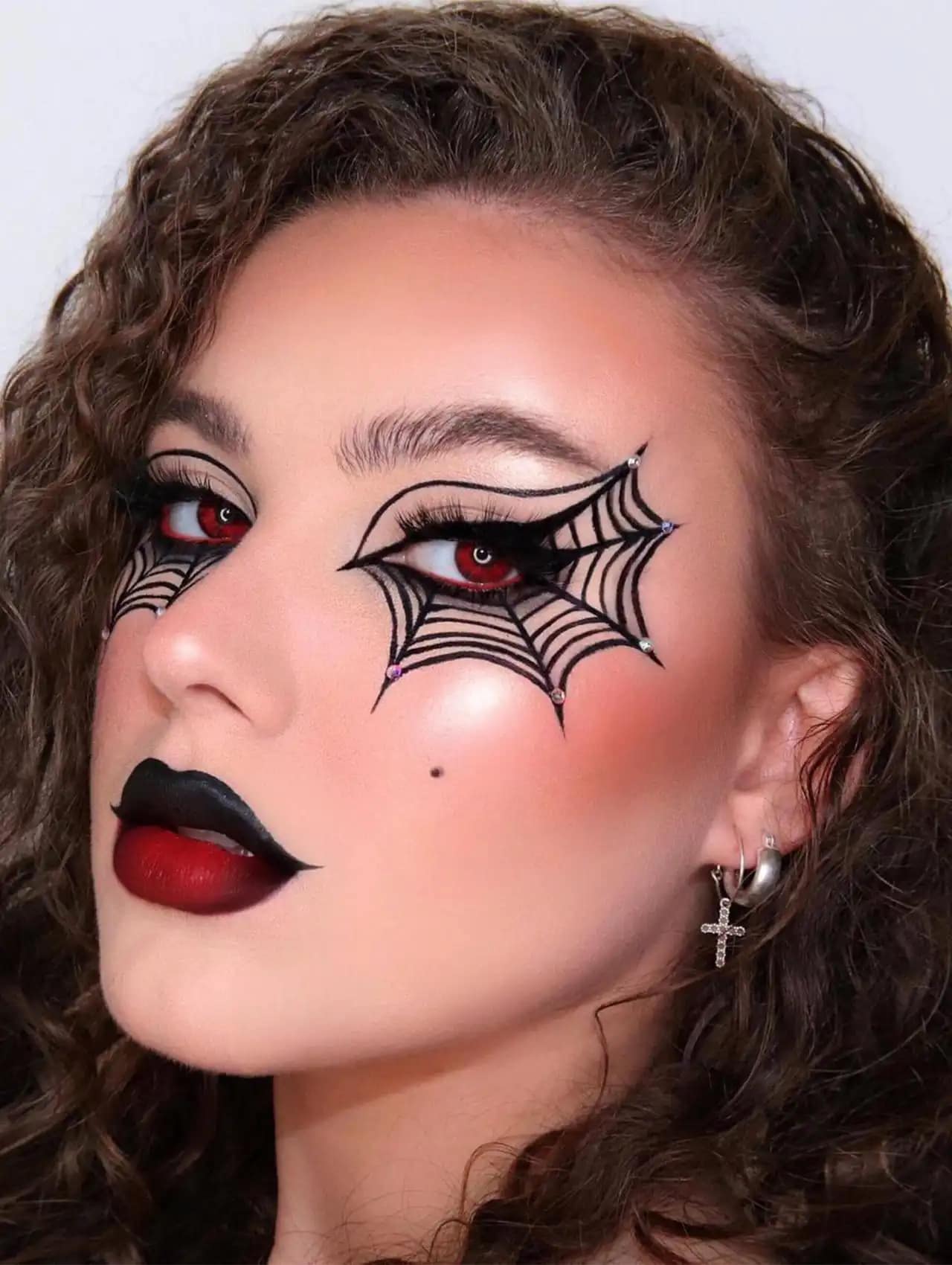 Spiderweb halloween makeup looks with dramatic black and red eye design and bold lips.