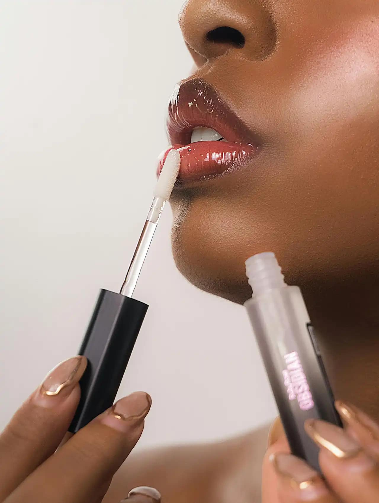 Labios con gloss aplicando brillos transparentes