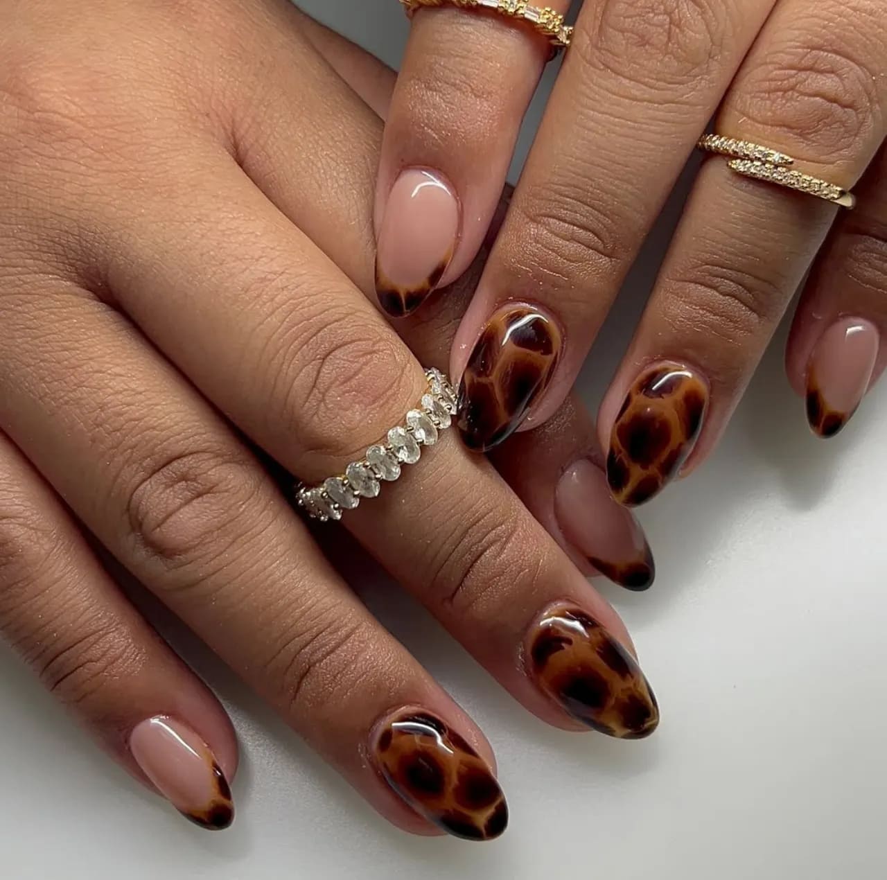 Diseño de uñas animal print estilo carey en tonos marrón y negro.