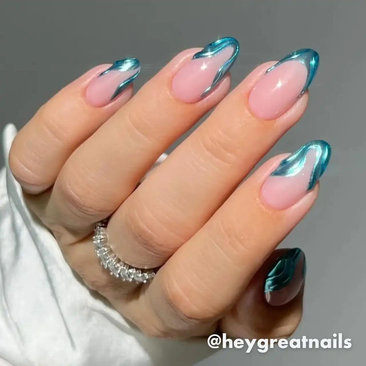 Diseños de uñas acrílicas glamurosas con acabado metálico azul brillante.