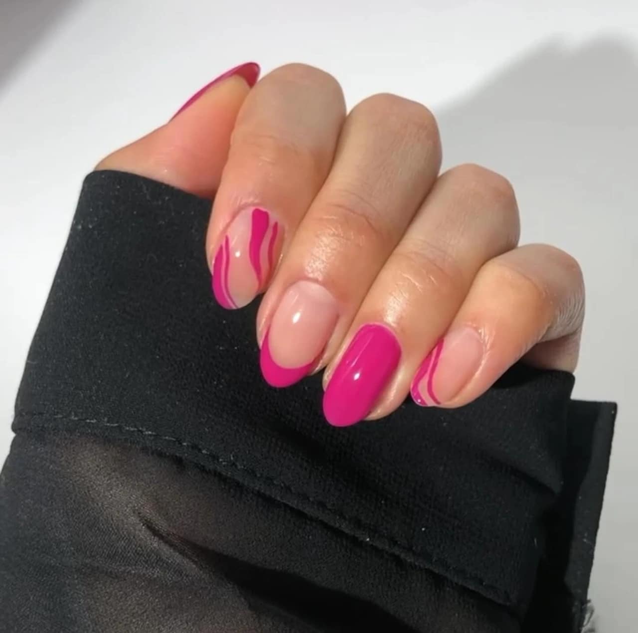 Diseños de uñas acrílicas con patrón rosa y detalles ondulados sobre base nude.