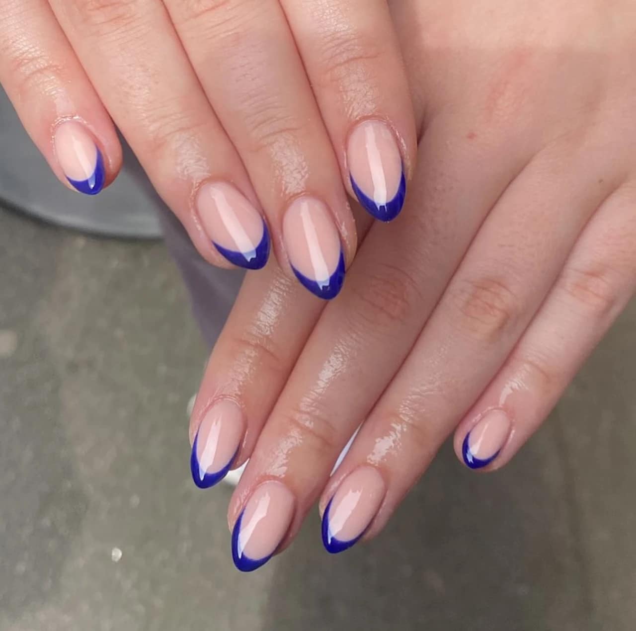 Diseños de uñas acrílicas francesas con patrón azul en forma almendrada.