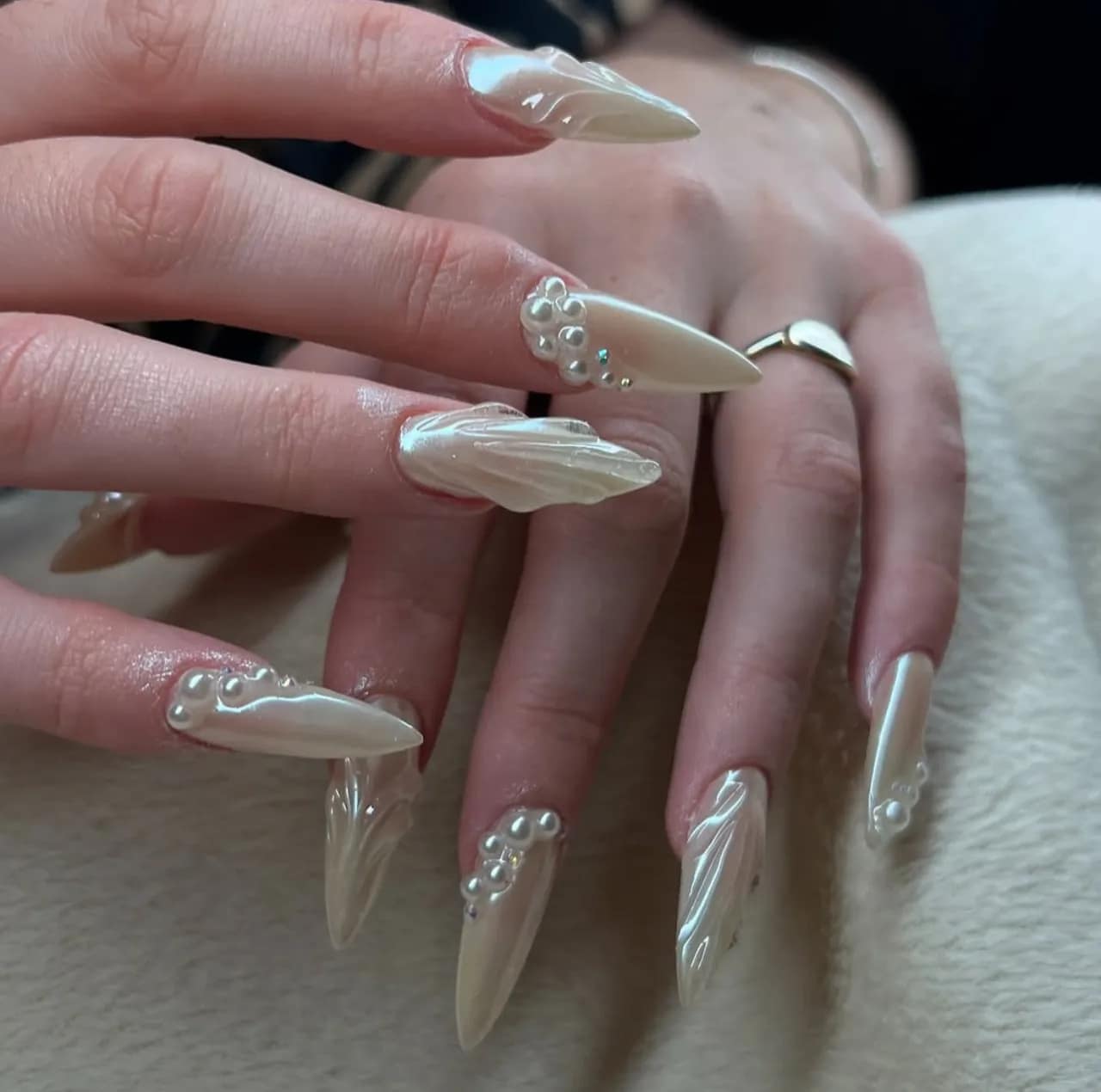 Diseños de uñas acrílicas estilo sirena con acabado nacarado y perlas decorativas.