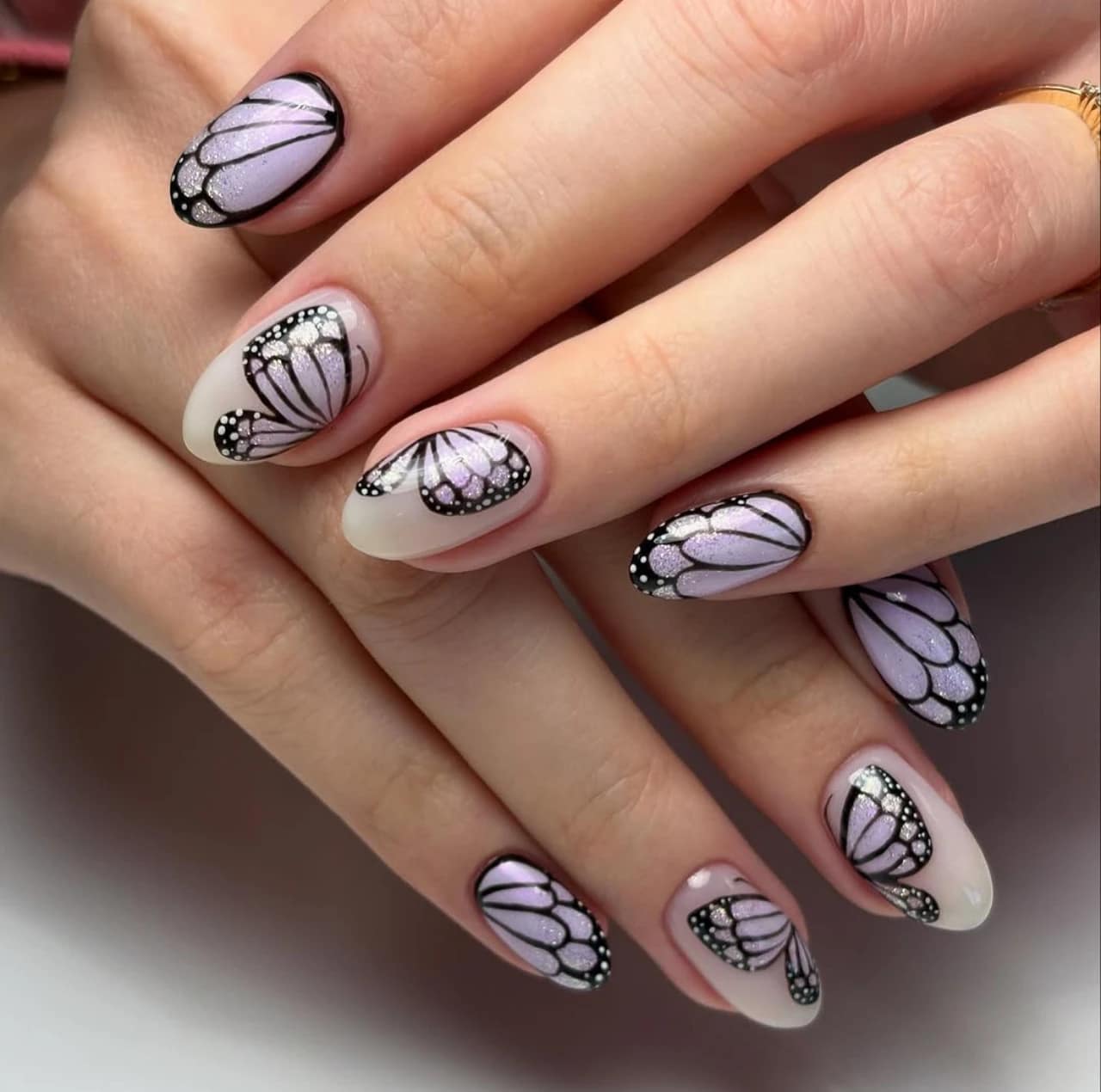 Diseño de uñas mariposa con efecto glitter en tonos lilas – diseños de uñas acrílicas.