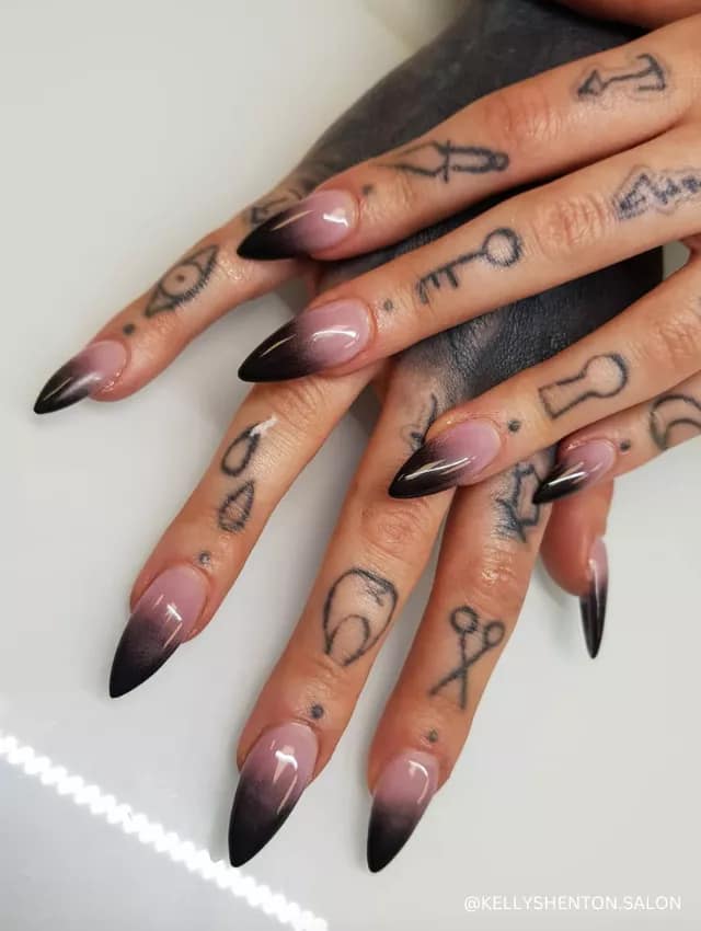A striking black ombre nail design with a smoky gradient effect on long stiletto nails.